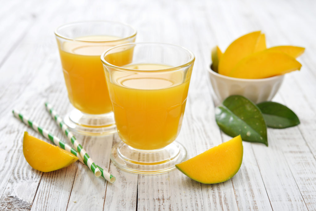 Mango juice in a glass on wooden white background - © fotolia